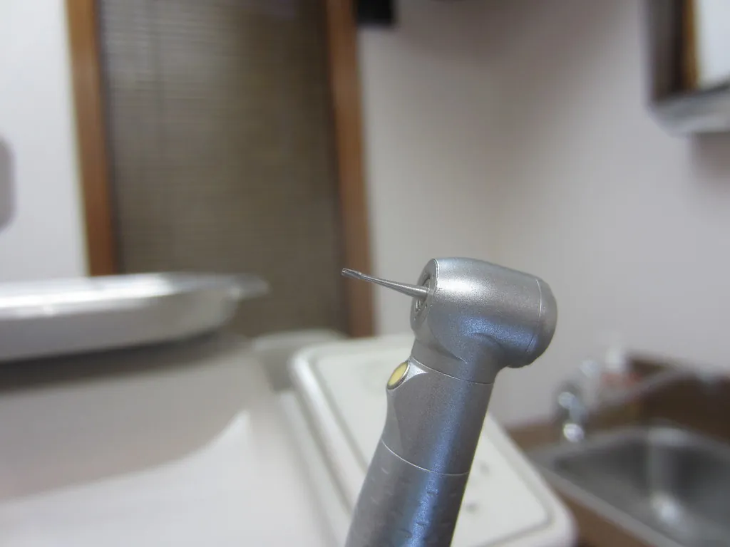 Turbina dental en primer plano junto a la escupidera